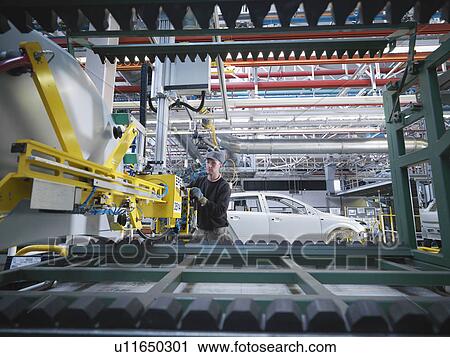 Stock Image - Car Plant Worker With Machinery. Fotosearch