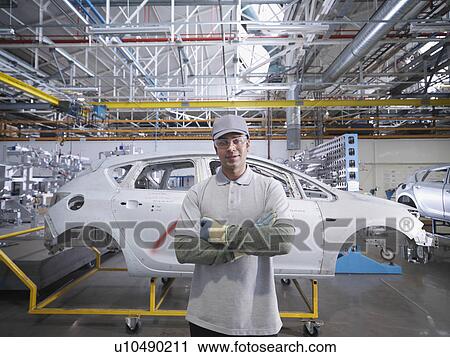 Stock Image - Car Plant Worker With Shell Of Car. Fotosearch
