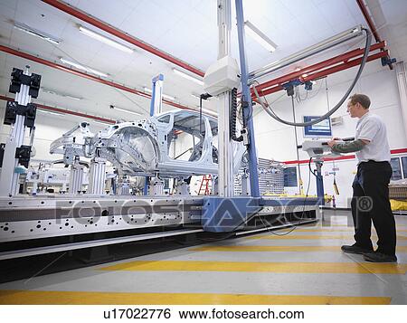 Stock Photograph - Car Plant Worker With Shell Of Car. Fotosearch
