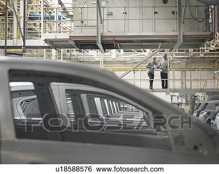 Stock Photograph - Car Plant Workers Observing Cars. Fotosearch