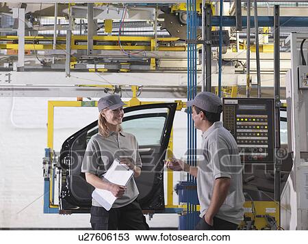 Stock Image - Car Plant Workers On Production Line. Fotosearch