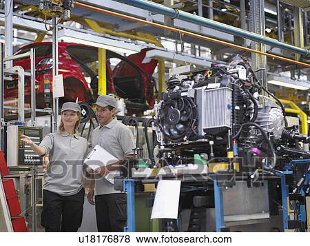 Stock Photo - Car Plant Workers With Car Parts. Fotosearch