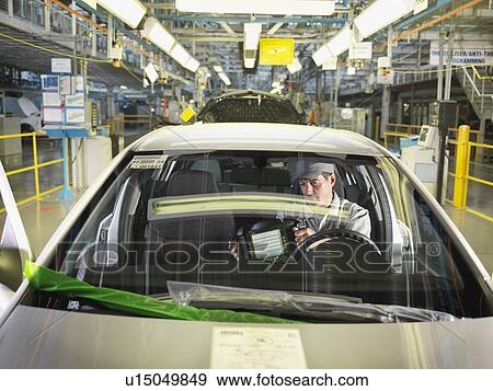Stock Photo - Car Worker In Car On Production Line. Fotosearch