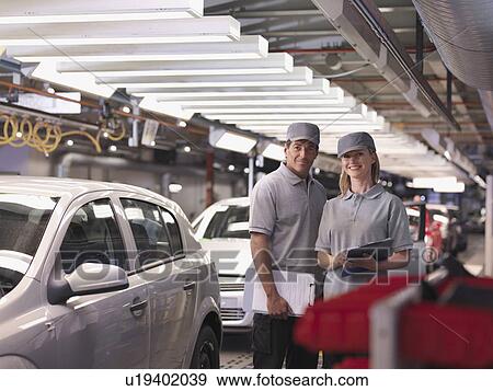 Stock Photo - Car Workers With Completed Cars. Fotosearch