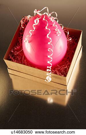 Stock Image - Cardboard box with pink party balloon. Fotosearch