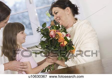 Stock Photo - Child giving her grandmother flowers. Fotosearch