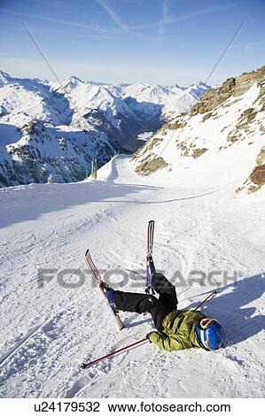 Stock Image - Child on skis lying in the snow.. Fotosearch