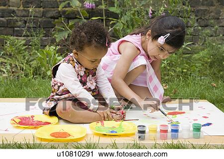 Stock Image - Children Painting in the garden. Fotosearch