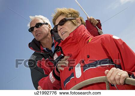 Concentrating couple sailing yacht View Large Photo Image Stock Photograph - Concentrating couple sailing yacht. Fotosearch