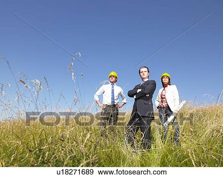 Stock Photo - contractors with blueprints in field. Fotosearch
