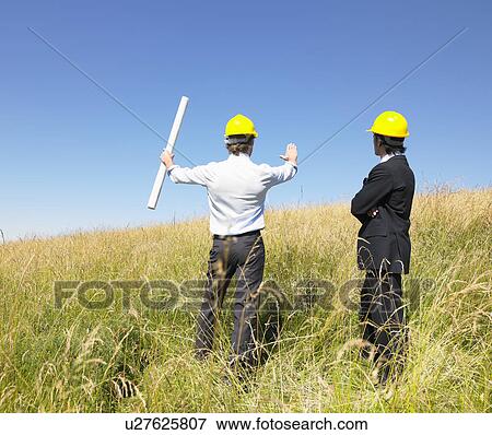 Stock Photo - contractors with blueprints in field. Fotosearch
