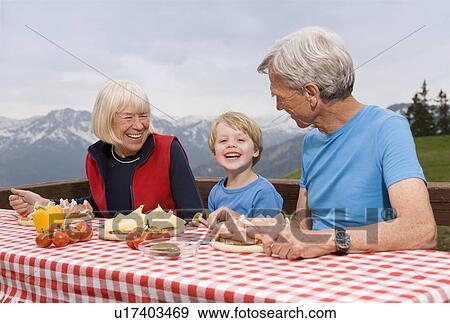 Stock Photo - couple and grandson eating in mountains. Fotosearch