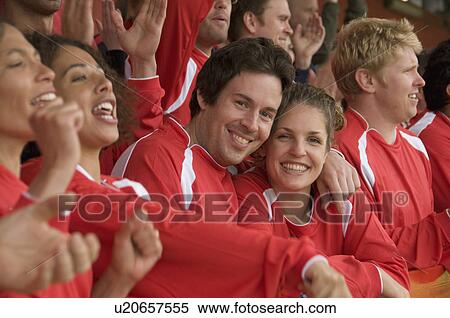 Stock Photography - Couple cuddling at football match. Fotosearch