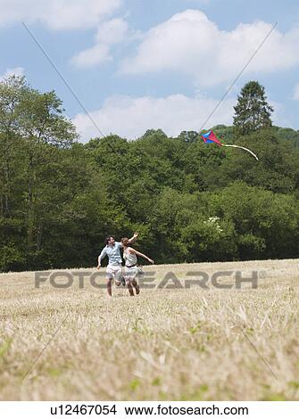 Picture - couple flying kite. Fotosearch