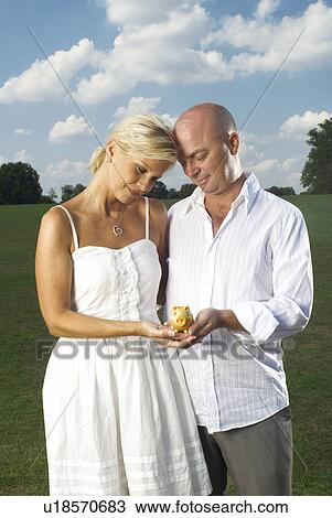 couple holding little piggy bank View Large Photo Image Stock Image - couple holding little piggy bank. Fotosearch