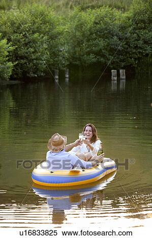 Stock Photography - Couple in dinghy on a country lake. Fotosearch