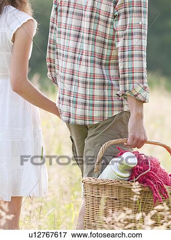 Stock Photo - couple in hats walking through meadow. Fotosearch