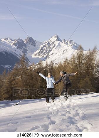 Stock Photo - couple jumping in the snow. Fotosearch