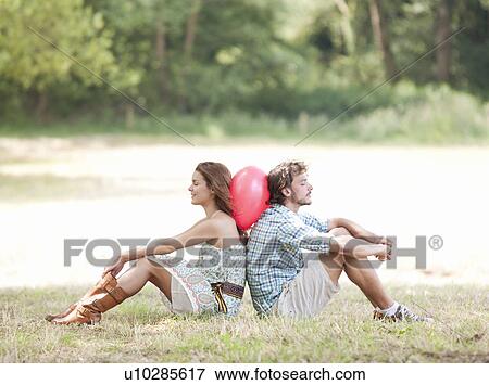 Stock Photo - couple leaning on balloon. Fotosearch
