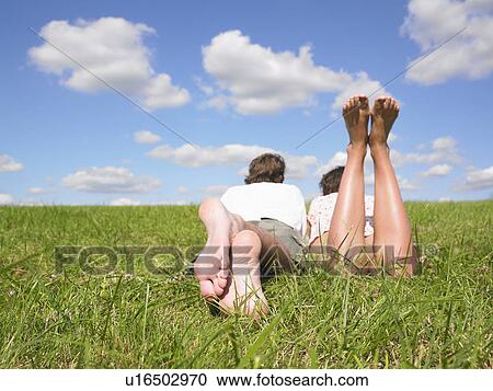 Stock Image - couple lying in field. Fotosearch