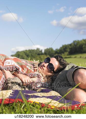 Stock Image - couple lying in field. Fotosearch