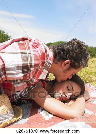 Stock Image - couple on blanket in field. Fotosearch