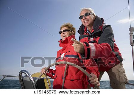 Stock Photo - Couple sailing yacht. Fotosearch