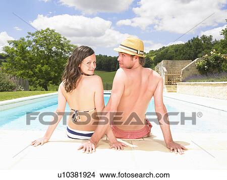 Picture - couple sitting by pool. Fotosearch