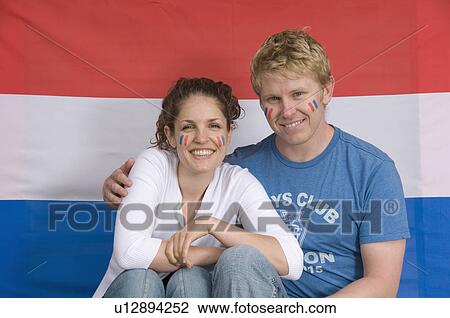 Stock Image - Couple smiling with Dutch flag. Fotosearch