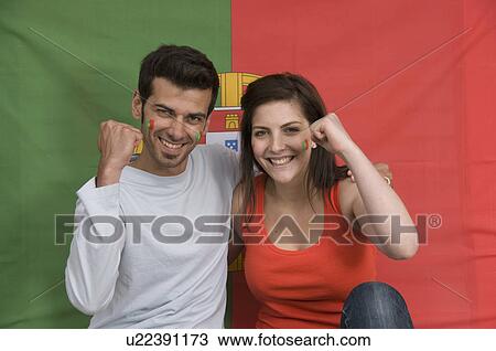 Stock Image - Couple smiling with Portuguese flag. Fotosearch