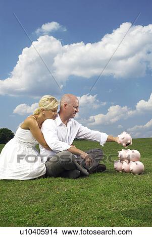 couple stacking piggy banks View Large Photo Image Picture - couple stacking piggy banks. Fotosearch