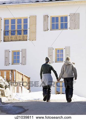 Stock Image - couple walking and holding hands. Fotosearch