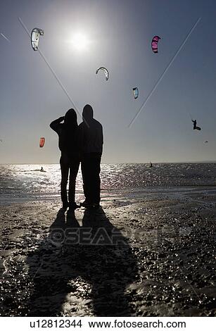 Picture - Couple watching kite boarders. Fotosearch