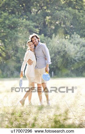 Stock Photograph - Couple with rackets in country field. Fotosearch