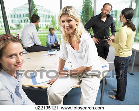 Stock Image - Coworkers in the office, talking. Fotosearch