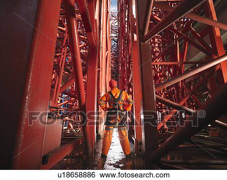 Stock Photograph - Crane Worker Looking Up A Cranes. Fotosearch