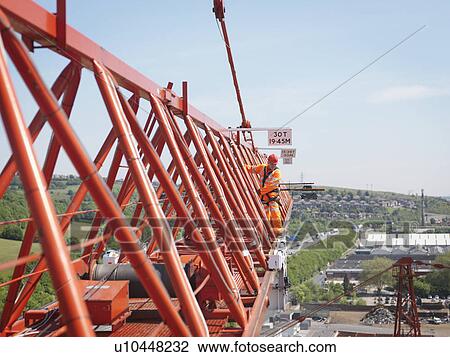 Stock Image - Crane Worker On Arm Of Crane. Fotosearch