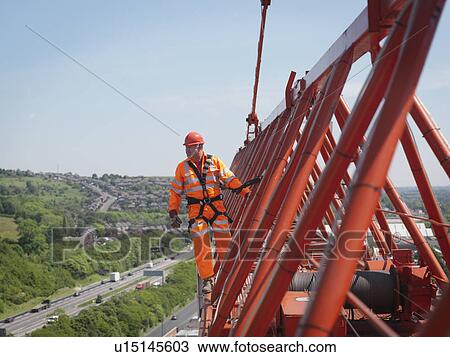 Stock Image - Crane Worker On Arm Of Crane. Fotosearch