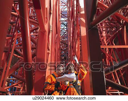 Stock Image - Crane Workers Discussing Cranes. Fotosearch