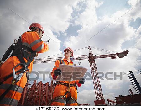 Stock Image - Crane Workers In Harnesses. Fotosearch
