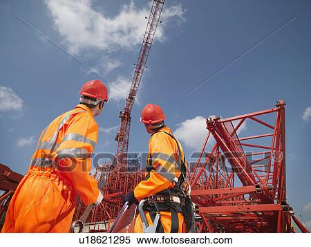 Stock Photography - Crane Workers Looking At Cranes. Fotosearch