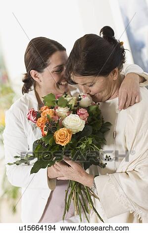 Picture - Daughter giving her mother flowers. Fotosearch