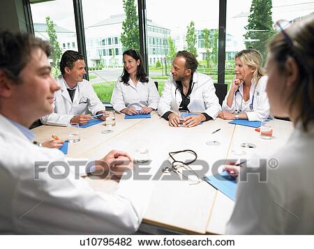 Stock Image - Doctors around a table. Fotosearch
