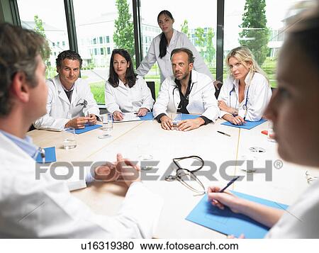 Doctors around a table View Large Photo Image Stock Image - Doctors around a table. Fotosearch