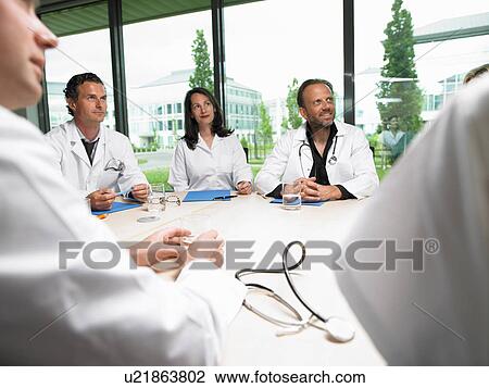 Doctors around a table View Large Photo Image Stock Image - Doctors around a table. Fotosearch