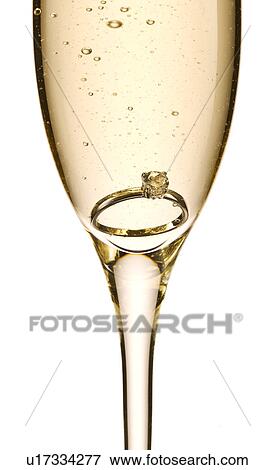 Engagement ring in glass of champagne View Large Photo Image Stock Photo - Engagement ring in glass of champagne. Fotosearch