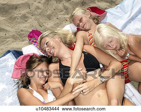 Picture - Family hugging at the beach. Fotosearch