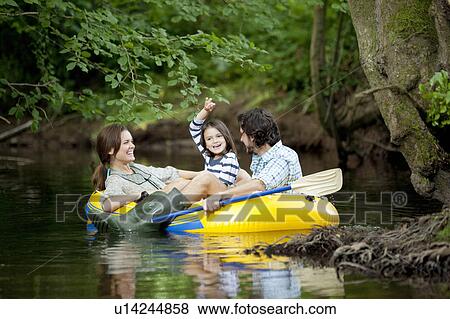 Stock Photo - Family in dinghy on lake. Fotosearch