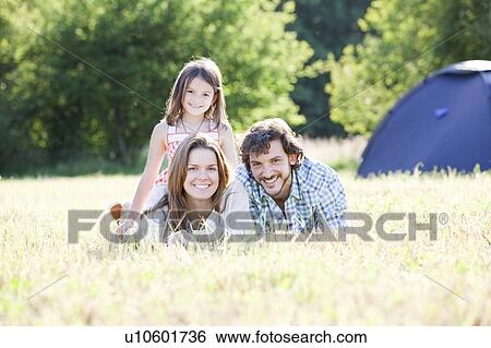 Stock Photograph - Family laying in grass in country scene. Fotosearch