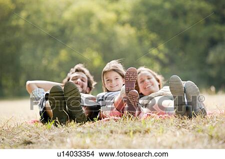 Family lying on blanket in countryside View Large Photo Image Picture - Family lying on blanket in countryside. Fotosearch